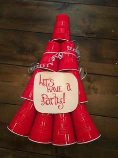 red cups are stacked on top of each other with a sign that says let's have a party