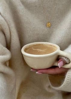 a woman holding a cup of coffee in her hands