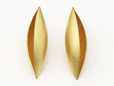 The simple, elegant forms of the Cocoon series are, perhaps, the highest expression of his formal aesthetic. The artist begins with sheet metal and imbues it with a soft and organic volume, over which light softly plays. This subtle interpretation of an elegant, organic form becomes sculpture on the body. His handmade pods are beautiful and revolutionary at once, equally alluring as they are architectural. Using an anticlastic technique, Erich hammers flat pieces of metal into unique, three-dime Elegant Sculptural Earrings For Formal Occasions, Sculptural Jewelry With Polished Finish For Formal Occasions, Elegant Sculptural Jewelry With Polished Finish, Modern Oval Earrings For Evening, Contemporary Sculptural Jewelry For Formal Occasions, Contemporary Teardrop Earrings, Contemporary Polished Earrings For Evening, Contemporary Polished Finish Evening Earrings, Elegant Sculptural Jewelry For Formal Occasions