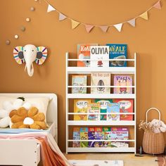 a child's room with bookshelf and stuffed animals on the wall above it