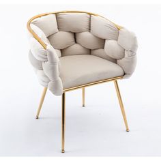 a white chair with gold legs and a beige upholstered cushion on the back