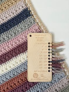 a crocheted blanket with a wooden ruler attached to the back and side of it