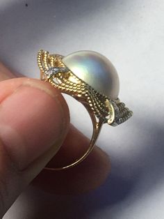 A beautiful Mave Pearl (genuine, cultured) set in 14K gold ring surrounded by diamonds. 4 strips of 3 diamonds each total 12 diamonds. The gold banding has a bend to it in the centers, which isn't necessarily shown the best in the photos. Beautifully made elegant ring great for anyone special High Luster Round Cut Rings For Formal Occasions, Formal Round Cut High Luster Rings, Formal High Luster Round Cut Rings, Exquisite Pearl Ring With Diamond Accents, Timeless High Luster Diamond Jewelry, Elegant Silver Dome Ring In 14k Gold, Elegant Diamond White Dome Ring With Prong Setting, Elegant Formal Rings With High Luster, White Gold Rings With High Luster For Formal Events