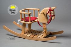 a wooden rocking horse with a red seat on it's back and the words royal toy written below