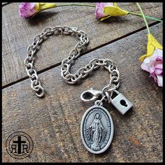 We are proud to offer this women's Consecration to Mary bracelet at such an affordable price. Our version has Our Lady's Miraculous Medal and a small Lock to remind you of your devotion. Antique Silver medal Chain Sturdy lobster clasp. Fits up to size 8.25 inches. Official Act of Consecration to Mary (DOWNLOAD a printable version HERE) Written by St. Maximilian Kolbe O Immaculata, Queen of Heaven and earth, refuge of sinners and our most loving Mother, God has willed to entrust the entire order Miraculous Medal Bracelet Jewelry Gift, Spiritual Rosary Bracelet With Lobster Clasp As Gift, Spiritual Metal Rosary Bracelet As Gift, Spiritual Stainless Steel Jewelry With Lobster Clasp, Spiritual Chain Bracelet With Lobster Clasp As Gift, Spiritual Metal Chain Bracelet With Lobster Clasp, Queen Of Heaven And Earth, Combat Rosary, St Maximilian Kolbe