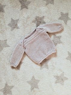 a baby sweater is laying on the carpet