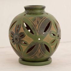 a green vase sitting on top of a white table