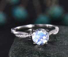 a white gold ring with an oval cut blue topazte surrounded by small diamonds