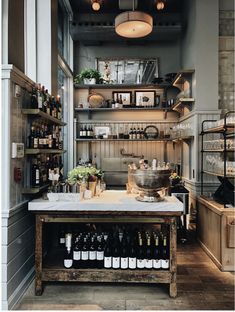 a kitchen filled with lots of bottles of wine and cooking utensils on top of a wooden table