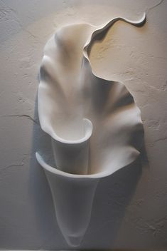 a white vase sitting on top of a wall