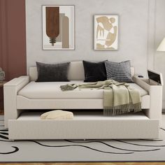 a living room with a white couch and some black and white pillows on it's side