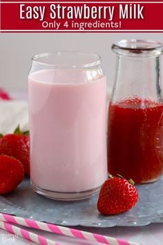 strawberry milk and strawberries sit on a tray next to two glass containers with the same liquid in them