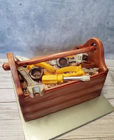 a wooden box filled with tools on top of a table