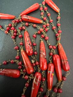 Vintage red glass ceramic beaded gilt metal chain link long end of day bead necklace 110cm Vintage Red Jewelry With Dangling Beads, Vintage Red Necklace With Dangling Beads, Red Vintage Necklace With Dangling Beads, Red Single Strand Long Necklace, Red Double Strand Beaded Chain Jewelry, Unique Red Glass Necklace, Vintage Red Beaded Necklaces With Oval Beads, Red Beaded Lariat Jewelry, Red Beaded Double Strand Jewelry