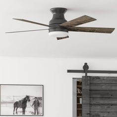 a ceiling fan mounted to the side of a wall in a room with white walls