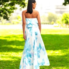 Step into effortless elegance with the Blue Lagoon 2-piece skirt set. Featuring a delicately pleated maxi skirt paired with a flirty tiered ruffle bandeau top, this set brings a soft, ethereal vibe perfect for any sunny day. The serene watercolor print in soothing blues and whites evokes a dreamy, cloud-like look that flows with your every step. Whether you’re attending a garden party or an outdoor event, this ensemble promises comfort and style. Pair it with your favorite sandals or heels for a Summer Long Flowy Skirt Set, Two-piece Set With Flowy Skirt For Summer, Blue Flowy Maxi Skirt With Ruffles, Blue Tiered Beach Skirt, Summer Blue Two-piece Set, Blue Lagoon 2, 2 Piece Skirt, The Blue Lagoon, 2 Piece Skirt Set