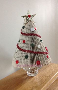 a christmas tree made out of books on top of a wooden table