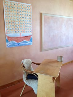 a room with a wooden table and chair next to a large painting on the wall