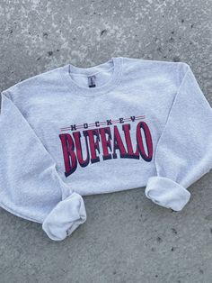 This Vintage Hockey Crewneck Sweatshirt is a must-have for any retro sports fan! Made with a high-quality sublimation print on a soft and cozy 50/50 cotton/polyester blend crewneck sweatshirt, this shirt is built to last. Available in sizes small through 5X, it's size-inclusive and perfect for anyone who loves a vintage aesthetic. Product Description: -Vintage-inspired hockey design -Size-inclusive, available in small through 5X -Sublimation printed on soft 50/50 cotton/polyester blend crewneck Vintage Nike Volleyball Sweatshirt, Vintage Varsity Sweatshirt, Sports Sweatshirt Designs, Fall Throwback T-shirt With Letter Print, Throwback Tops With Letter Print For Sports Events, Fall Throwback Letter Print T-shirt, Varsity Crew Neck Sublimation Design With Graphic Print, College Fan Apparel In Cotton With Sublimation Design, Cotton Logo Print Sweatshirt For Game Day