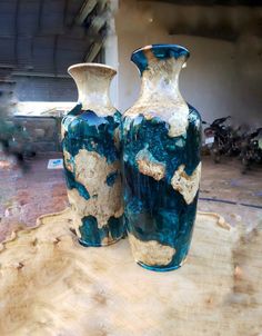 two vases sitting on top of a wooden table