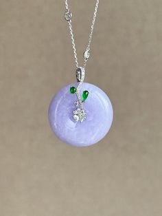 Elevate your style with this stunning intense vibrant purple jade donut pendant set in a stylish 18k white gold curvy design and paired with a vivid green jadeite cabochon. The donut shape symbolizes unity and wholeness, while the purple jade has a rich color that catches the eye. The green jadeite cabochon adds a pop of color and contrast, and the 18k white gold setting is sleek and modern. Perfect for any occasion, this pendant is made with attention to detail and quality. Materials: 18k White Luxury Adjustable Jade Jewelry, Round Jade Cabochon Necklace, Purple Round Jade Jewelry, Donut Pendant, Donut Shape, Purple Jade, Jade Bangle, Jade Earrings, Jade Necklace