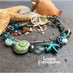 "◾One of a kind Artisan Bracelet. Made with an assortment of gemstones, art beads and hill tribe silver beads make this beach themed bracelet. Easy to put on swirl hook closure.  ◾Length: 7 1/2\" ◾Ceramic Raku Snail Bead by Keith O'Connor ◾Gemstones include: Agate, Aventurine, Blue Tourmaline, Blue Apatite, Green Garnet, Fluorite, Howlite, Crazy Lace Agate, Mint Blue Opal 🩴The Beachy Jewelry collection ... This collection celebrates the Ocean and Beach. Lots of Sea Life charms and colors. Very Turquoise Starfish Beaded Bracelets, Ocean-inspired, Ocean-inspired Turquoise Bracelets As Gift, Turquoise Ocean-inspired Bracelets As Gift, Ocean-inspired Turquoise Starfish Beaded Bracelets, Turquoise Ocean-inspired Bracelets For Gift, Turquoise Gemstone Beads Bracelets For Beach, Handmade Turquoise Starfish Bracelets, Ocean-inspired Turquoise Beaded Bracelets For Gift, Handmade Turquoise Beaded Bracelets In Ocean Style