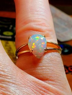 14k solid gold opal ring, beautiful opal with many bright rainbows adorning it mounted on a gold split shank ring. The ring is light and easy to wear and comes in 6 sizes I can swap the stone into. Yellow Gold Opal Ring In Fine Jewelry Style, Classic Yellow Gold Opal Ring, Anniversary Ethiopian Opal Ring In Yellow Gold, Fine Jewelry Yellow Gold Opal Ring, Hallmarked Opal Promise Ring In Fine Jewelry Style, Yellow Gold Ethiopian Opal Ring For Anniversary, Yellow Gold Opal Birthstone Ring, Yellow Gold Ethiopian Opal Anniversary Ring, Anniversary Solitaire Opal Ring