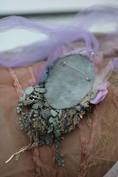 a woman's arm with an old piece of clothing on top of it and some plants growing out of the fabric