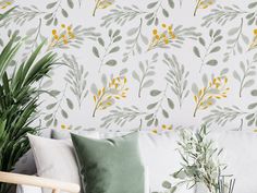 a white couch sitting next to a green plant on top of a wooden chair in front of a wall