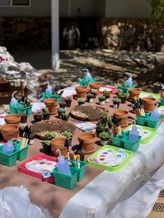 a table covered with pots and plants on top of it's tables cloths