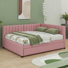 a pink bed sitting on top of a hard wood floor next to a green wall