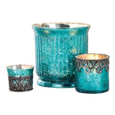 three teal colored glass candlesticks and one candle holder are sitting next to each other