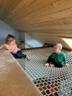 two young children playing on the floor in an attic