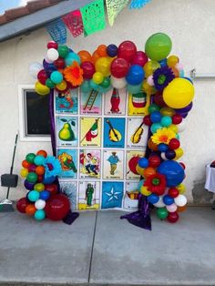 an arch made out of balloons on the side of a house