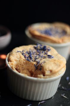 two small white dishes filled with food on top of a table