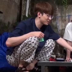 two young men sitting at a table with laptops