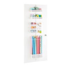 three different colored pencils are in a white wall mounted display case on a white background