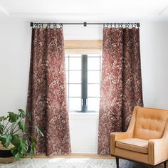 a living room with a chair, window and rug