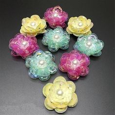 there are many different colored flowers with pearls in the center and on each flower is a pearl bead