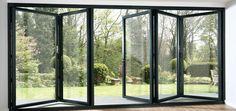 an open glass door in the middle of a room with wood flooring and white walls