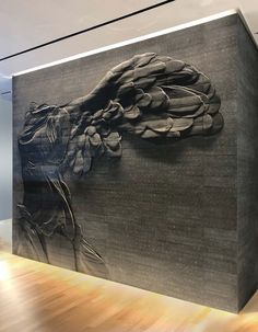 a large painting on the side of a wall in an office building with wood flooring