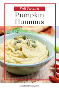 a bowl filled with pumpkin hummus on top of a wooden table