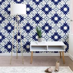 a blue and white patterned wallpaper in a living room next to a floor lamp