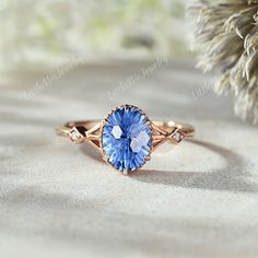 a blue stone ring sitting on top of a sandy ground next to a pine tree