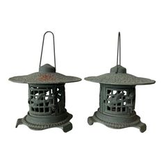 two metal lanterns sitting next to each other