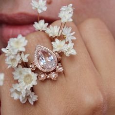 a close up of a person's hand holding a ring with flowers on it