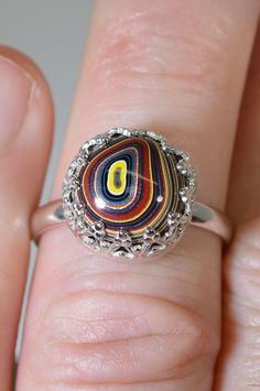 This sterling silver fordite ring is adjustable due to the split shank design. With the ends of the band touching it's a size 7 US. It goes slightly larger by spreading the band apart or smaller by bypassing the band. This fordite is from the Bowling Green KY plant where sports cars were painted in the early 2000's. It's one of the most valuable and desired fordite types. The setting is about .5 inches across. The ring setting is solid 925 silver. We handcrafted both the fordite stone and silver Unique Multicolor Rings With Polished Finish, Adjustable Multicolor Nickel-free Rings, Unique Multicolor Adjustable Rings, Multicolor Cabochon Sterling Silver Rings, Artisan Multicolor Sterling Silver Rings, Unique Multicolor Nickel-free Rings, Unique Multicolor Cabochon Rings, Adjustable Oval Multicolor Rings, Adjustable Multicolor Oval Rings