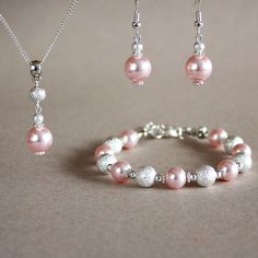 A contemporary 3-piece jewellery set featuring quality Swarovski pearls in lovely light pink blush colour (Rosaline) and bright silver plated stardust beads. Perfect for any occasion, weddings and parties or as a gift. Set contains pendant style necklace with a delicate silver plated chain, beaded bracelet and a pair of drop earrings. Organza gift bag included!  Please note that although I take a great care to keep the colours on the photographs as close to reality as possible, they may look sli Cheap Pink Jewelry With Silver Beads, Affordable Pink Jewelry With Silver Beads, Elegant Pink Sterling Silver Jewelry Sets, Pink Pearl Jewelry Sets For Gifts, Silver Pearl Jewelry Sets With Round Beads, Pink Pearl Jewelry Sets As Gift, Pink Pearl Drop Jewelry With Round Beads, Sparkling Silver Pearl Jewelry, Pink Round Beads Jewelry For Bridesmaid Gift