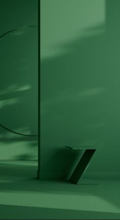 an empty room with green walls and a black square object on the floor next to it