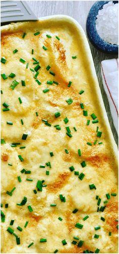 a casserole dish with cheese and green onions